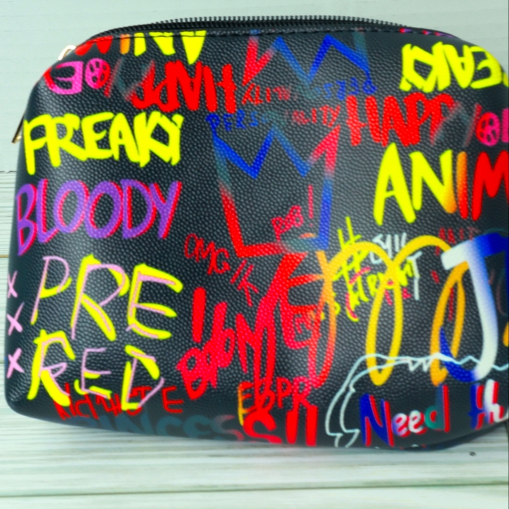 Handheld cosmetic bag with graffiti print and gold zipper
